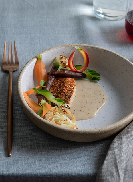 Bonbite catering plated entreé of seared snapper, heirloom carrots and cauliflower with a peppercorn cream sauce