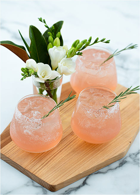 Bonbite catering specialty cocktail The Blushing Bride with gin and rosemary simple syrup and salted rim in stemless glass